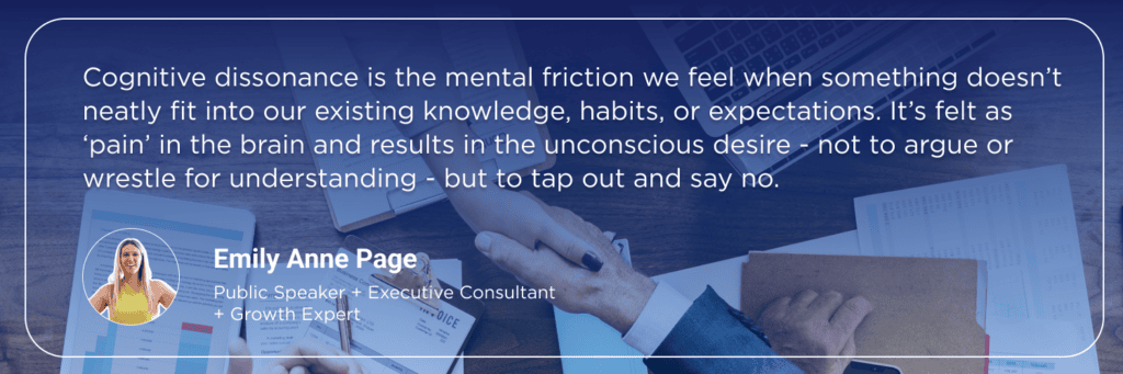 Quote graphic by Emily Anne Page about cognitive dissonance and decision-making, overlaid on an image of two people shaking hands across a desk with business documents and laptops.